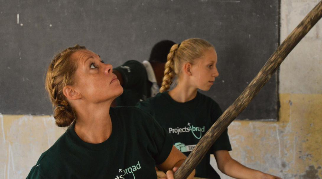 Durante su voluntariado en familia, madre e hija ayudan en labores de reconstrucción. Madre e hija trabajando juntas en un voluntariado de construcción en familia.